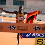 Victor Kiplagat celebrates Uganda's victory at the World Athletics Championships 2023 in Budapest, proudly holding the national flag