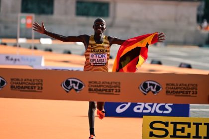 Victor Kiplagat celebrates Uganda's victory at the World Athletics Championships 2023 in Budapest, proudly holding the national flag